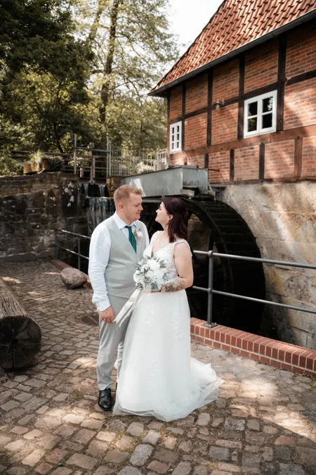 Brautpaar vor einer historischen Wassermühle