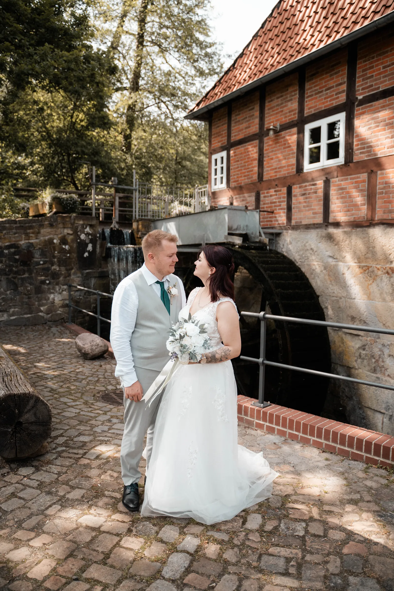Brautpaar vor einer historischen Wassermühle