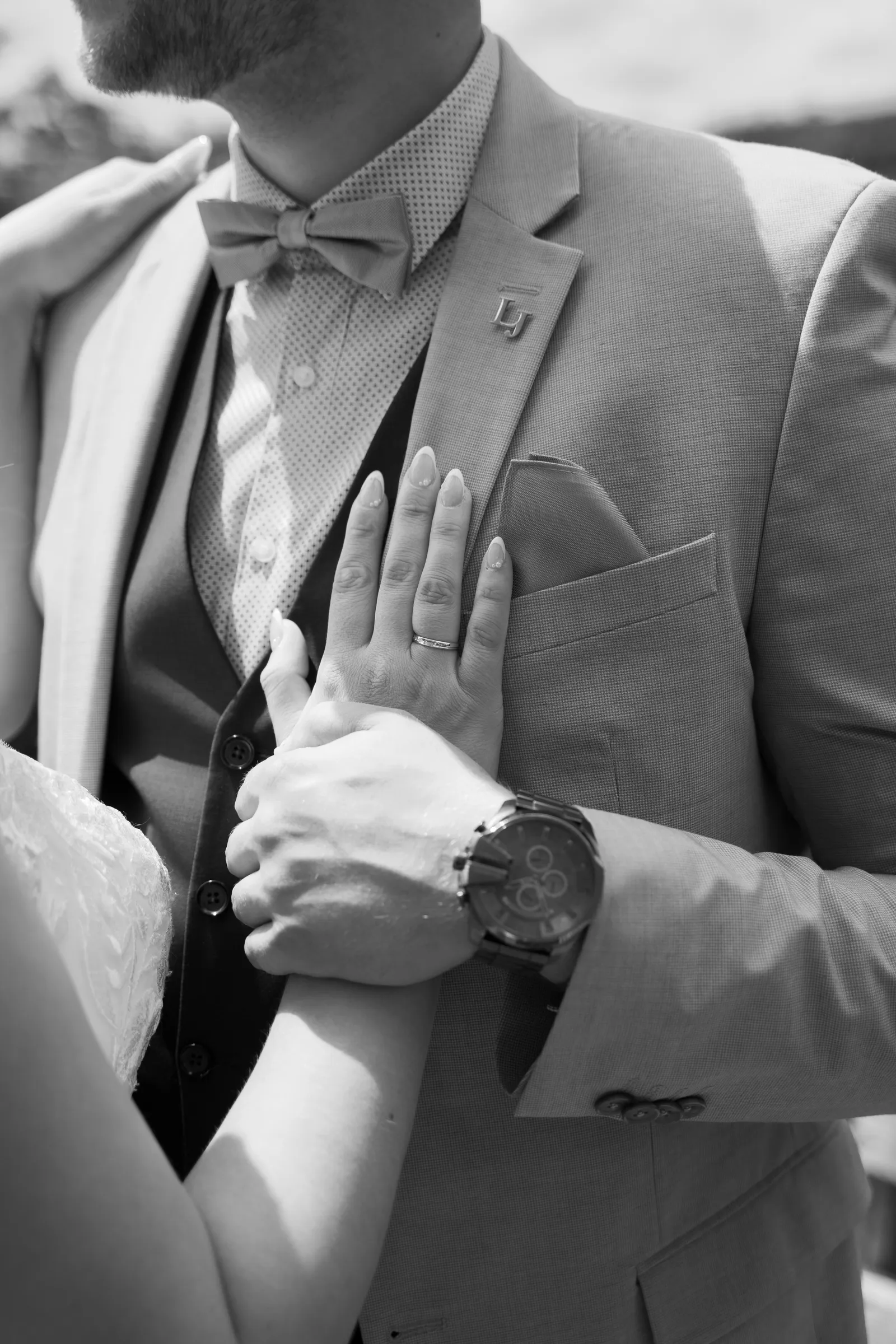 Detail: Hand der Braut auf dem Anzug des Bräutigams, Schwarz-Weiß