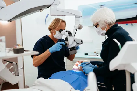 Zahnärztin und Assistentin behandeln eine Patientin