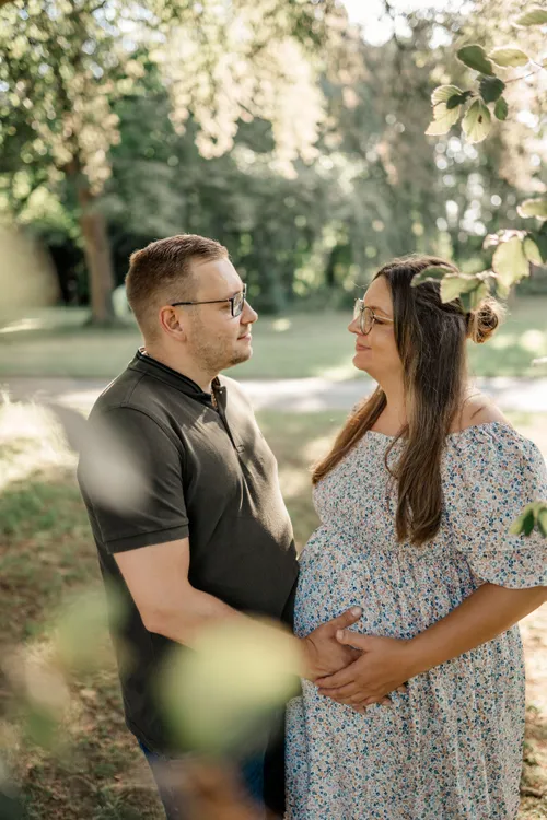 Paar mit Babybauch im Blickkontakt
